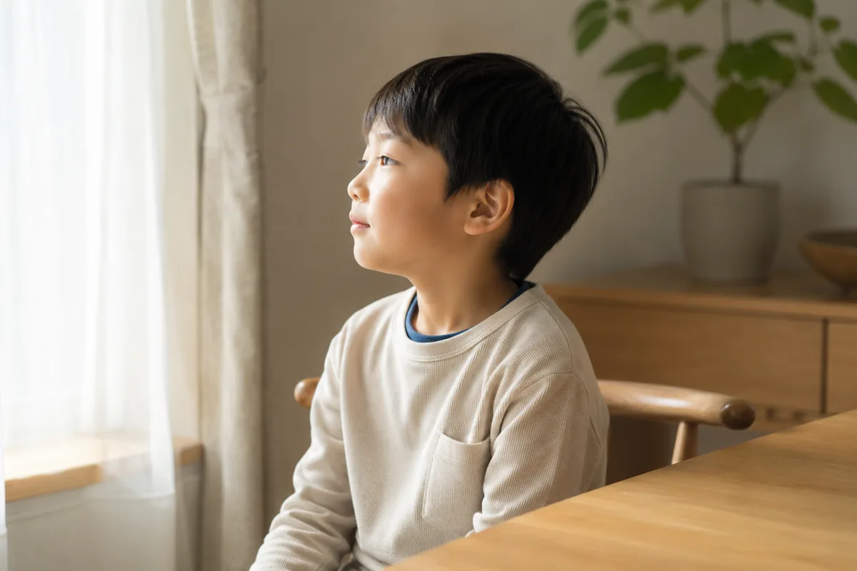 窓辺で穏やかに過ごす子どものイメージ